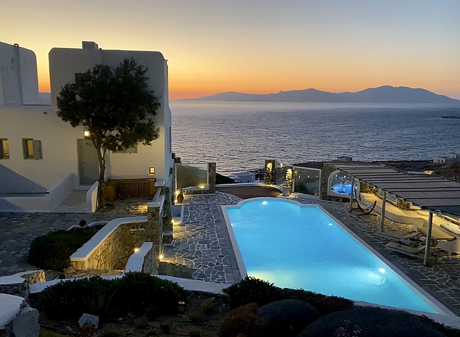 Luxury Mykonos Sunset Villa — la villa e la piscina al crepuscolo, con vista sull'Egeo / the villa and pool at dusk over the Aegean